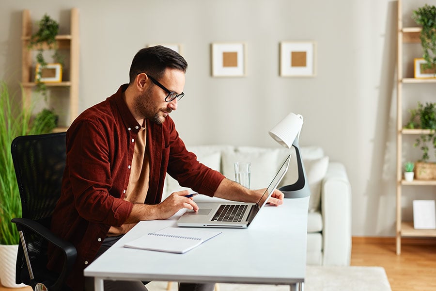 A man in casual clothes working in a home office