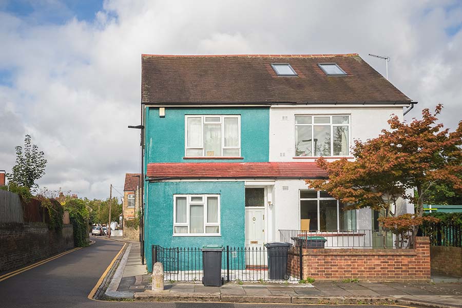 Semi-detached houses painted contrasting colours, one white and one bright blue
