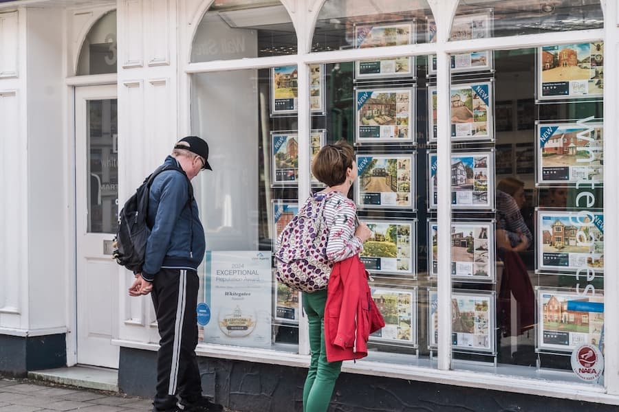 Couple looking at estate agent shop window