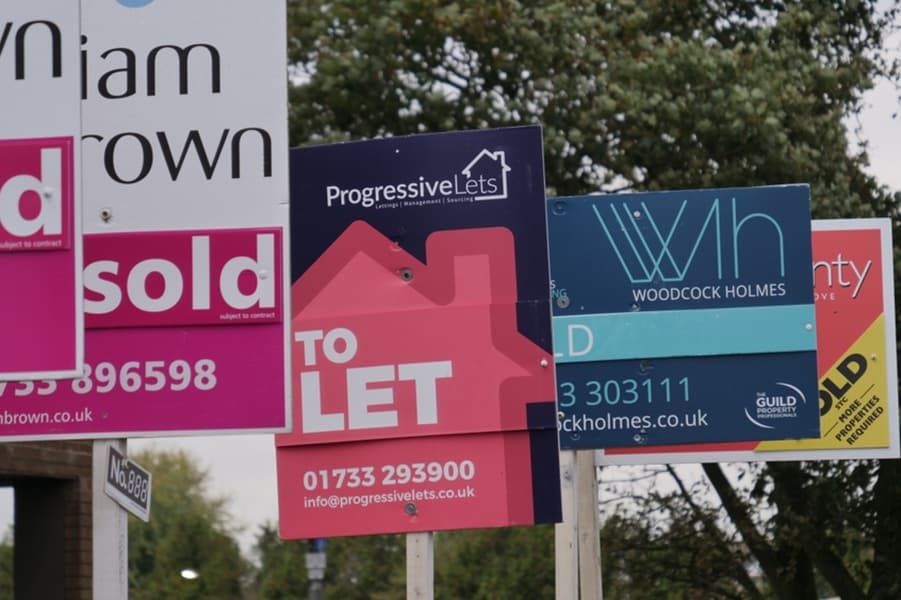 For sale signs line a residential street