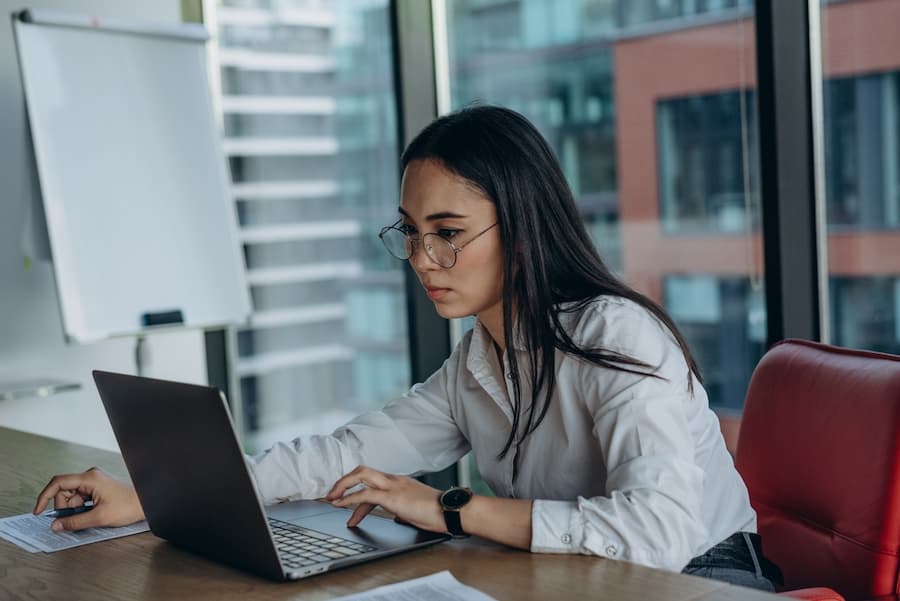 Serious asian business woman looking at a computer screen
