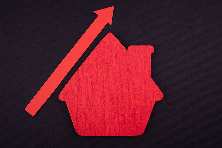 an outline of a house in red, with a red arrow pointing upwards next to it
