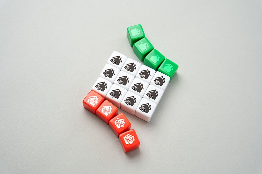 A series of plastic cubes with houses printed on them. Some of the cubes are arranged to point upwards, others point down