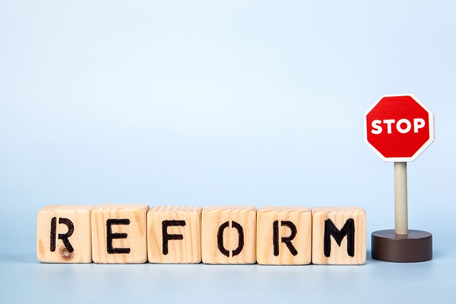The word reform spelt on wooden bricks, with a stop sign next to it