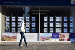 A person walking past an estate agent window