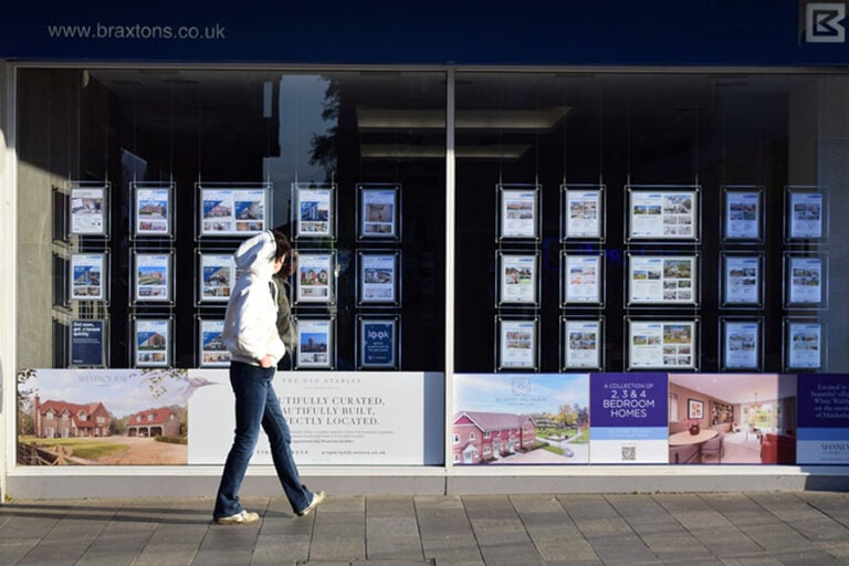 A person walking past an estate agent window