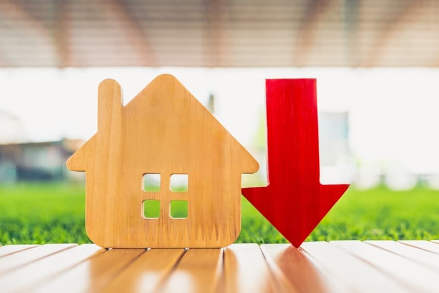 Image of house with down arrows. Concept of house transaction volume