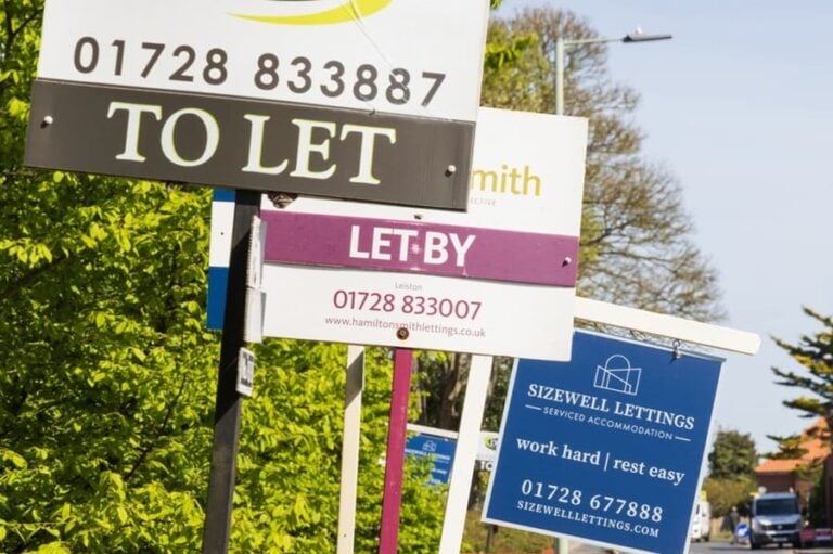 Local estate agent banners and for rent signs on a UK residential street