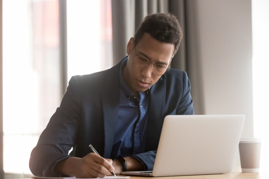 Serious african american young business man ceo wear suit making notes