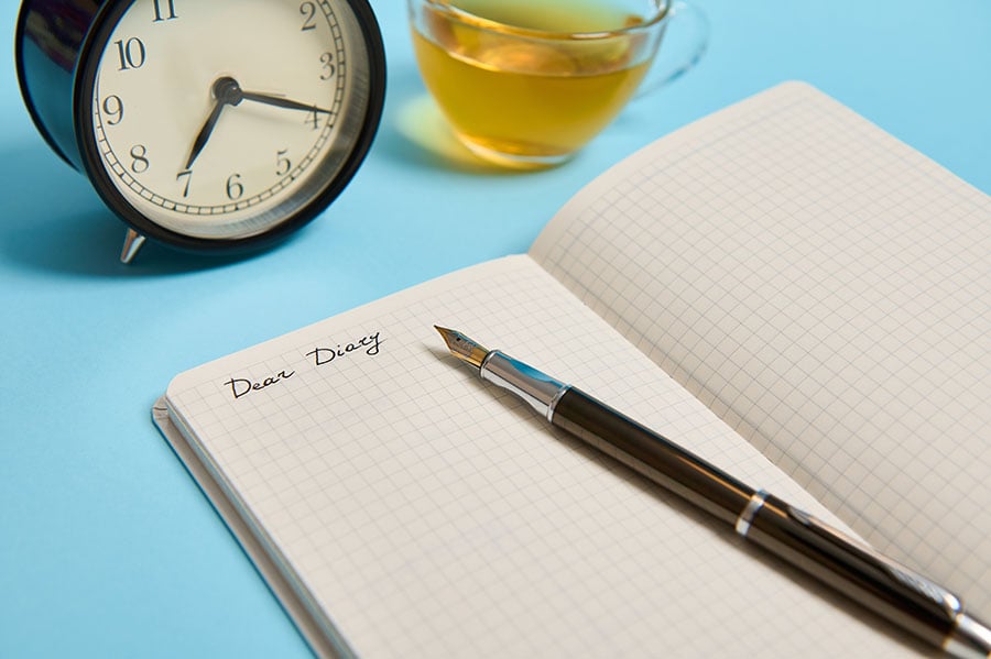 An open diary with a fountain pen laid across it