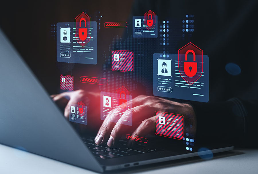 A graphic of digital ID symbols featuring padlocks in bright red is laid over hands typing on a laptop