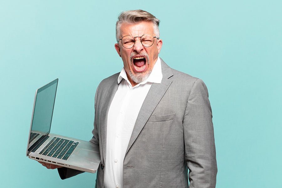 An angry looking man holding a laptop