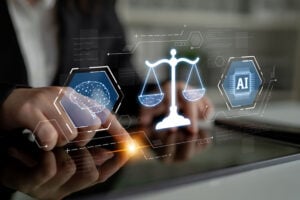 person pressing on screen in formal wear, with an image overlay, drawings of a brain on the left, scales of justice in the middle and 'AI' written on the right of the scales.