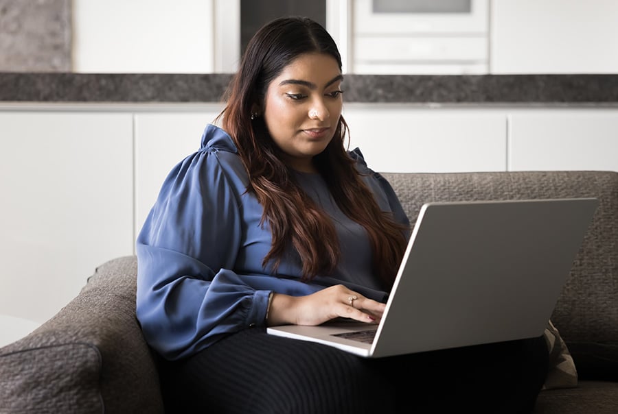 A young woman browsing a website on a laptop
