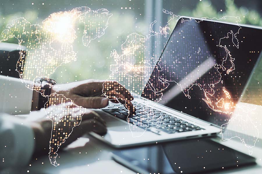A graphic of a digital map overlaid on a photo of hands typing on a laptop