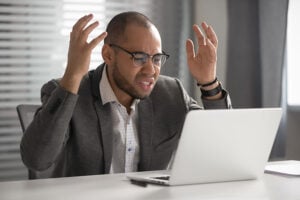 A frustrated man using a laptop