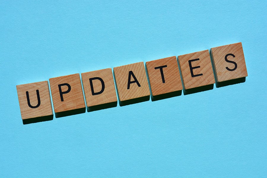 wooden blocks with letters spelling 'updates' on a plain blue background