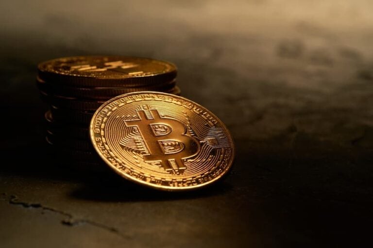 Various golden cryptocurrencies highlighting Bitcoin coin with dark textured background