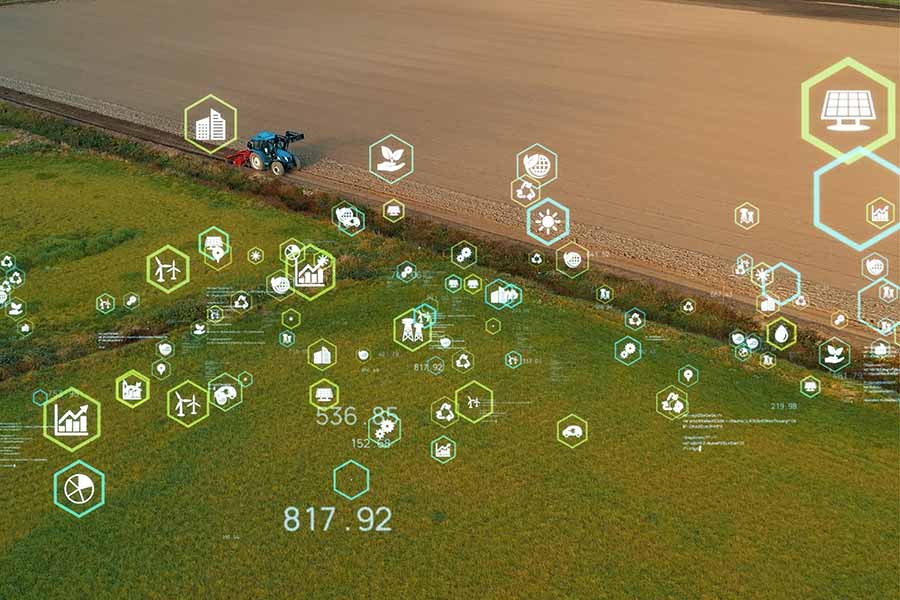 An overlaid graphic of multiple symbols depicting housing, tech and other sectors is overlaid a large agricultural field