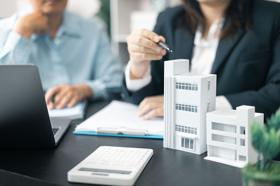 Business people discussing a model of a commercial building