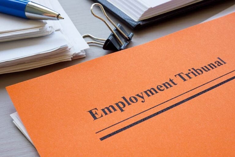A file printed with the words 'employment tribunal' and placed on a desk