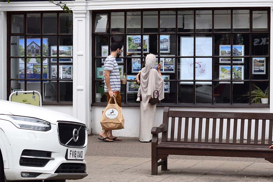 A couple look in an estate agent window
