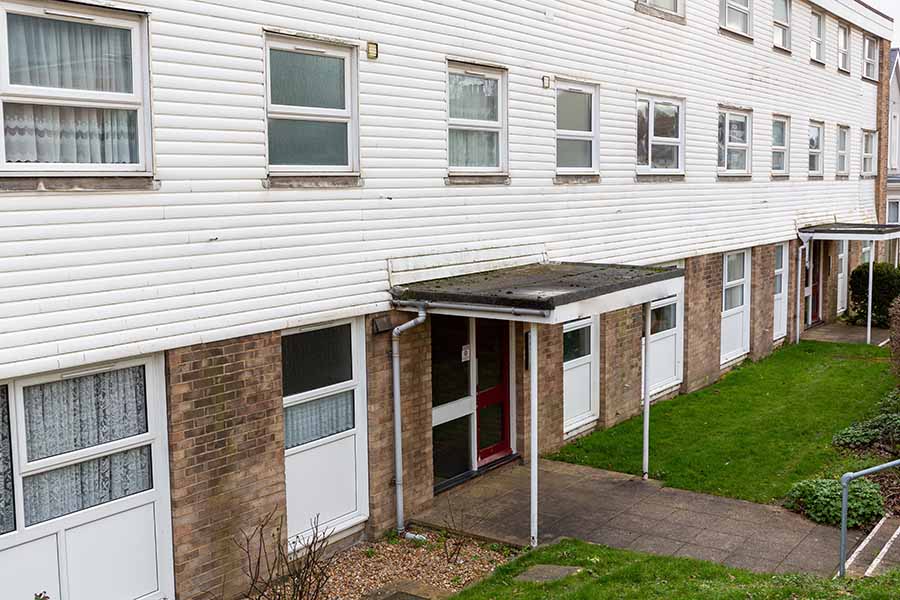A block of three-storey flats covered with white cladding
