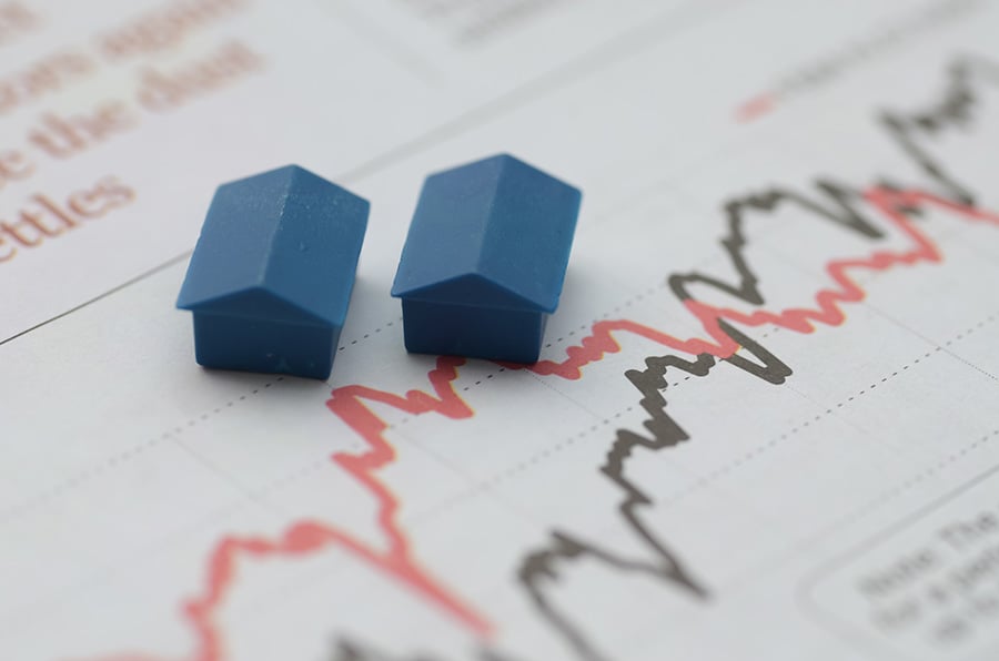 Two small model houses placed on top of a graph