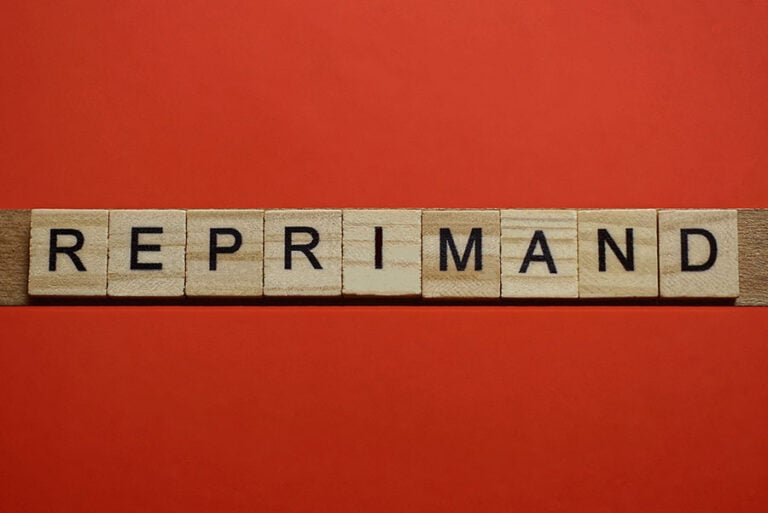 The word reprimand spelled on wooden tiles