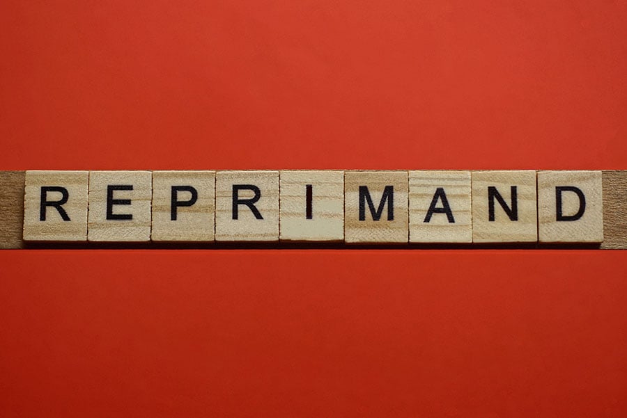 The word reprimand spelled on wooden tiles