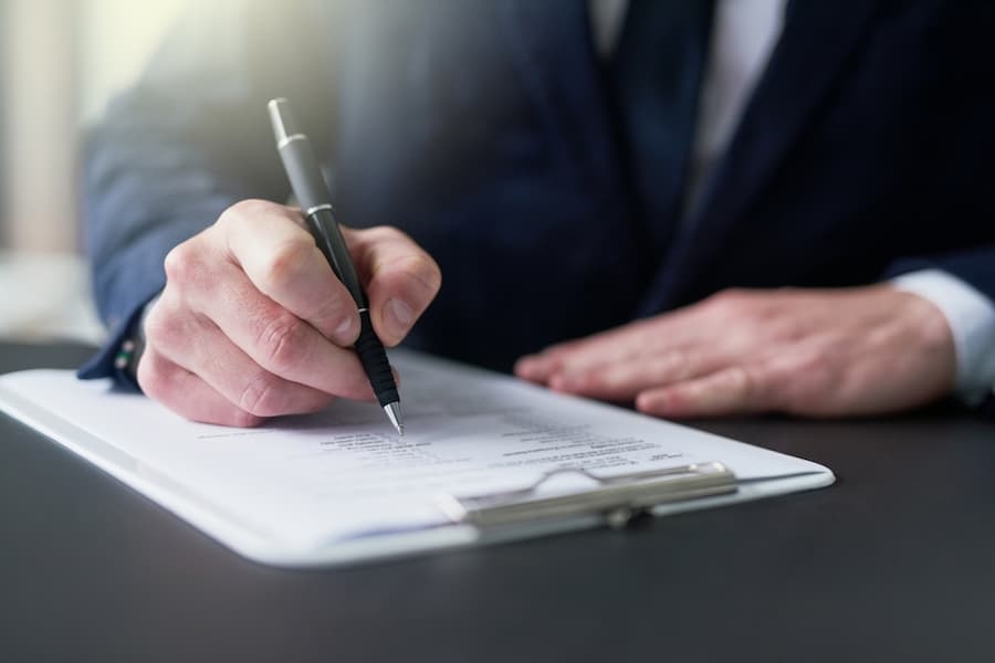 Businessman, hand and writing on document for signature for legal contract, agreement or deal for partnership as Lawyer