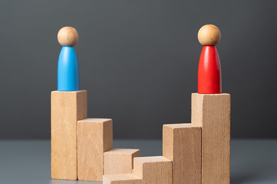 Two wooden figures, one red and one blue, on top of blocks