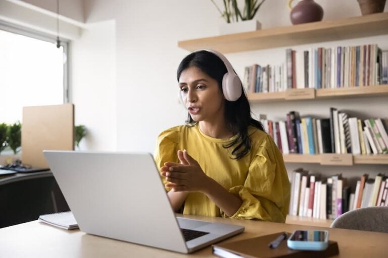 Digital interaction. Experienced young woman teacher tutor in wireless earphones