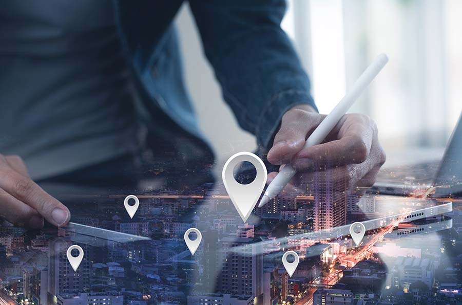 GPS map, pin address location on mobile apps. Double exposure of man hand using digital tablet searching target place on night cityscape while working on tablet