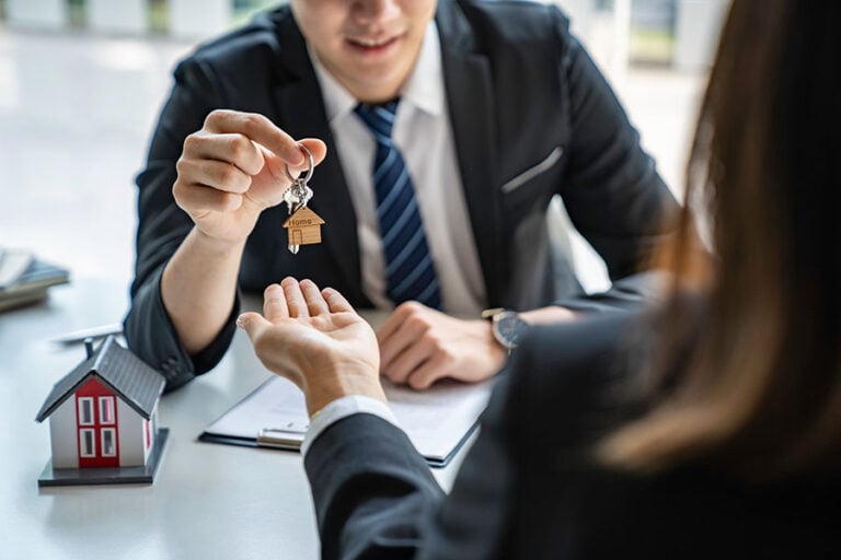 A conveyancer hands over a house key to a client